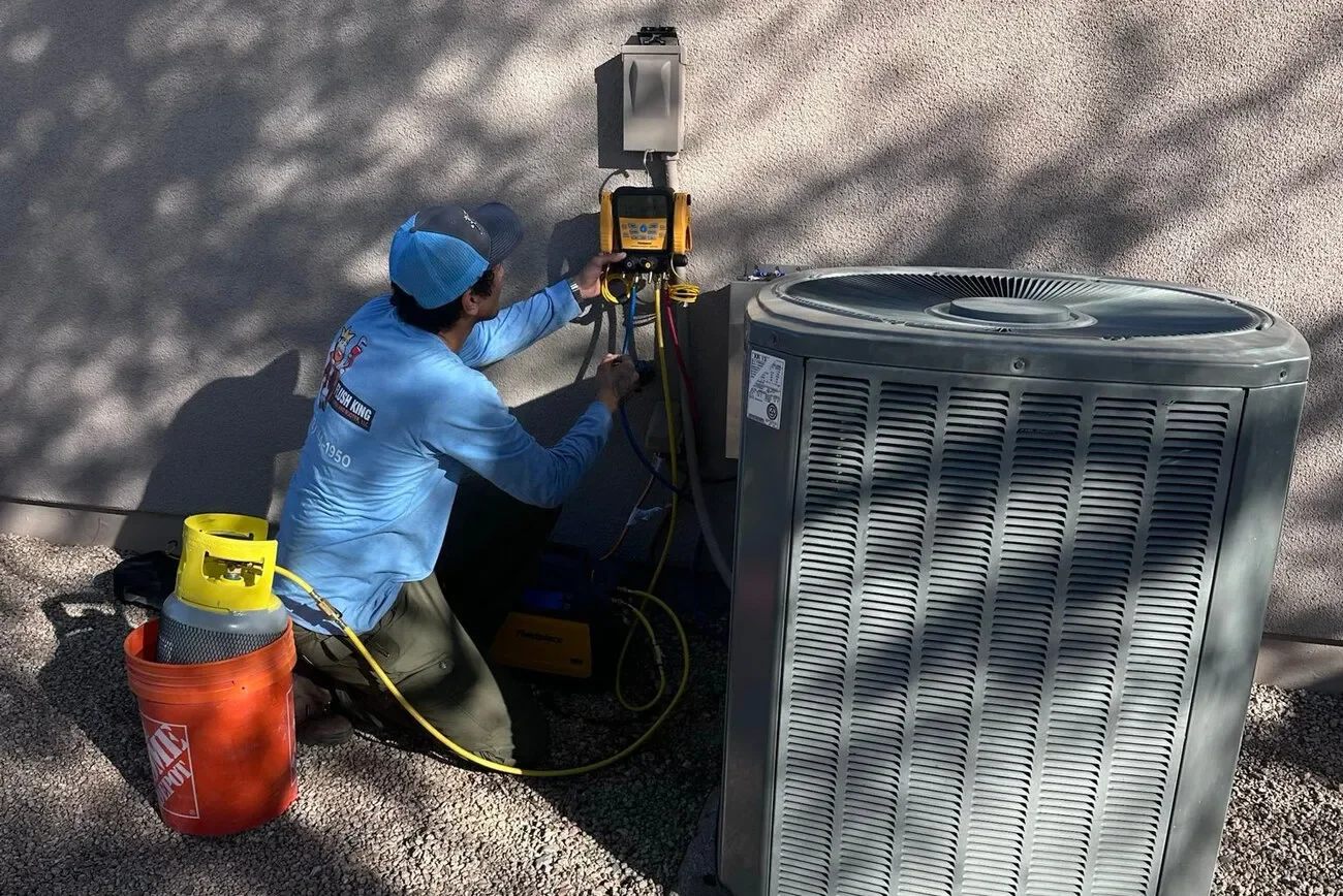 Technician performing AC coil cleaning and maintenance
