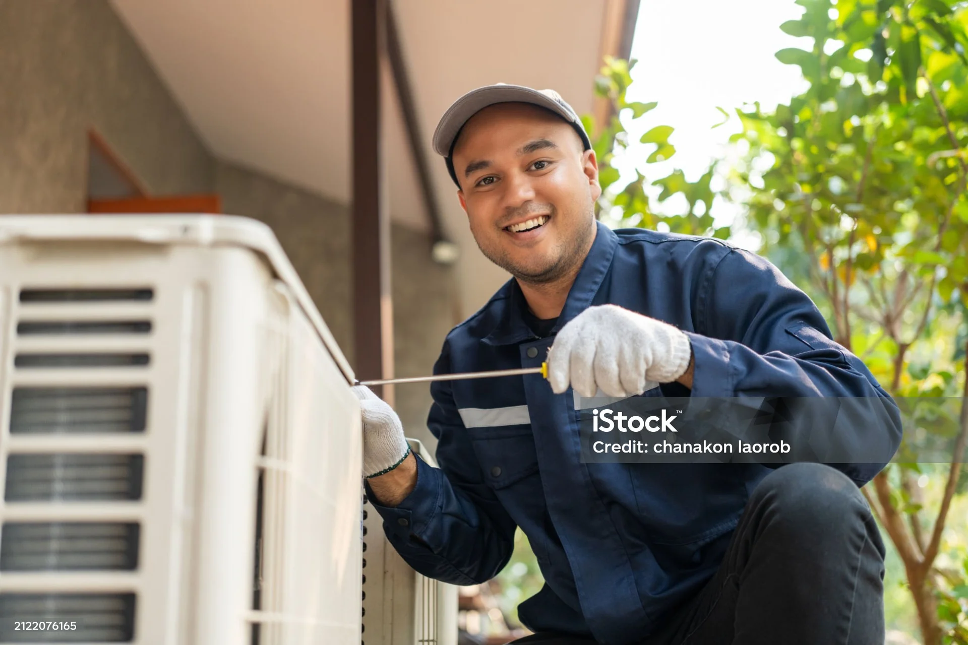 Professional AC technician diagnosing and repairing air conditioning system in Phoenix