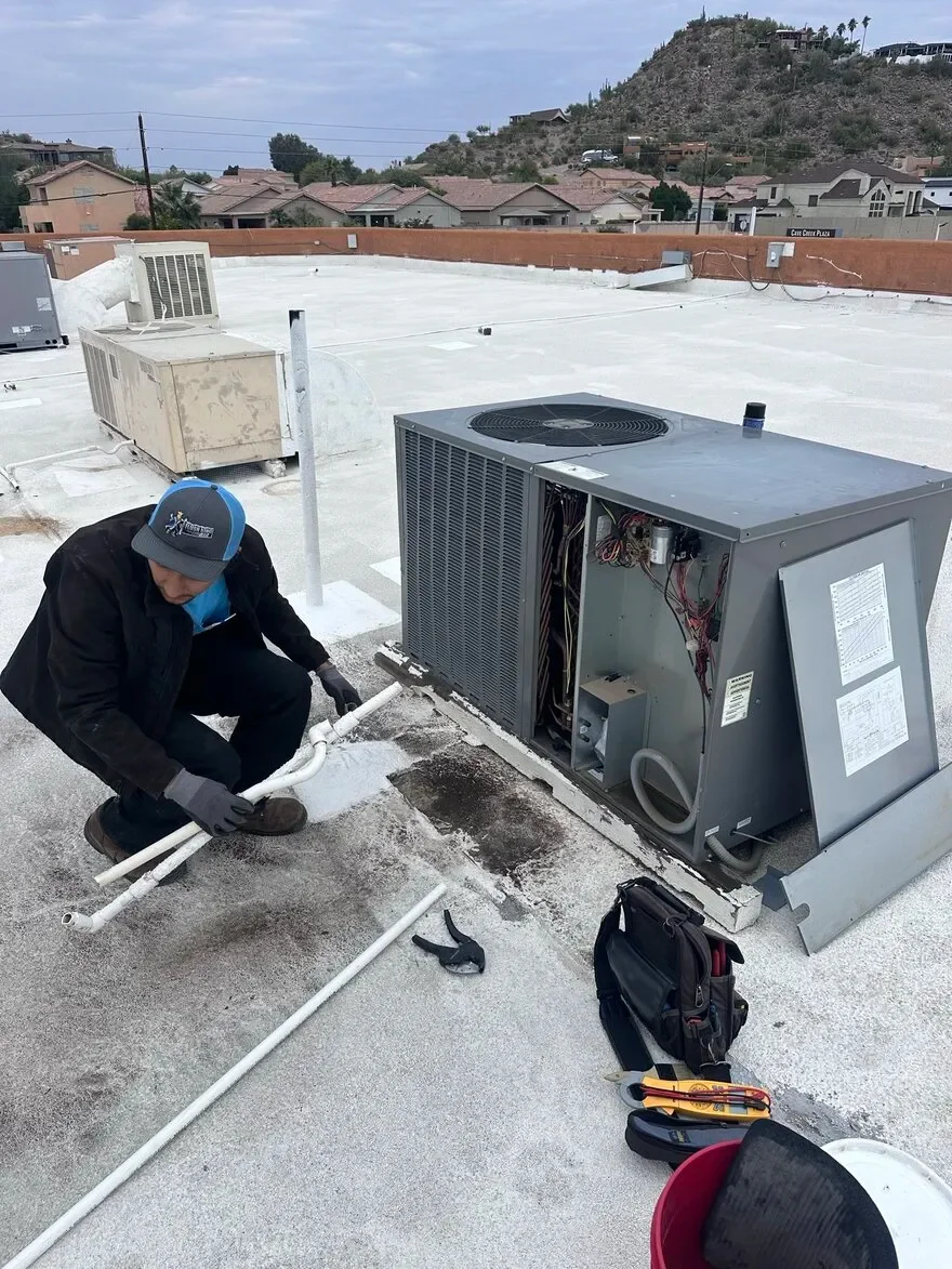 Technician installing rooftop AC unit in Phoenix