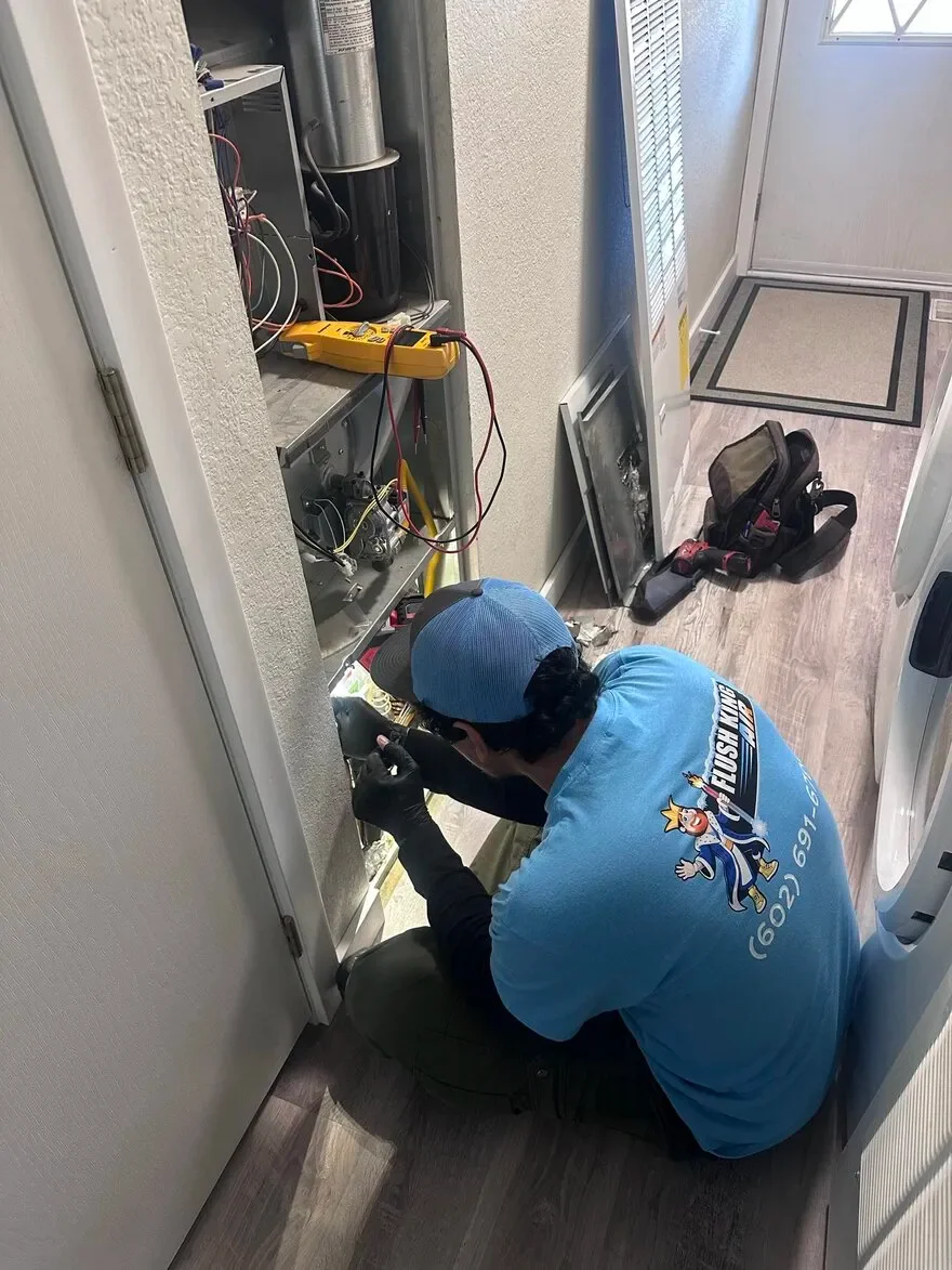 Technician performing emergency HVAC repair on indoor unit